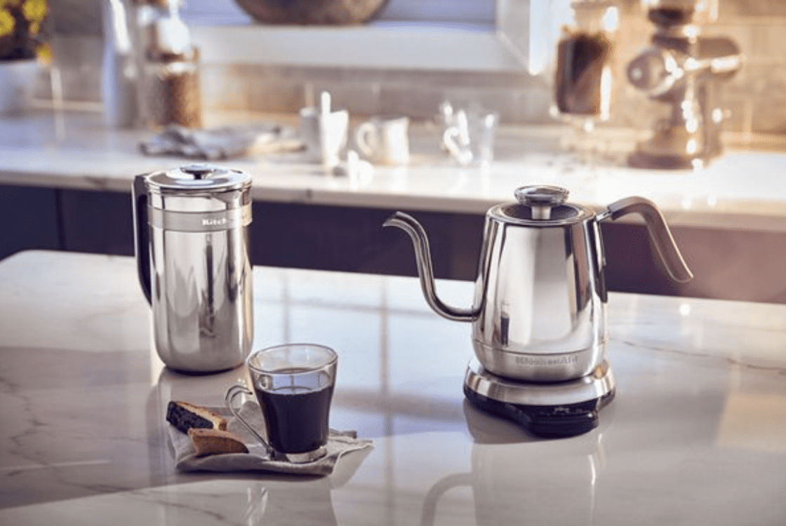 image of a precision kitchenaid kettle with a thin spout on a countertop with a coffee and frother.